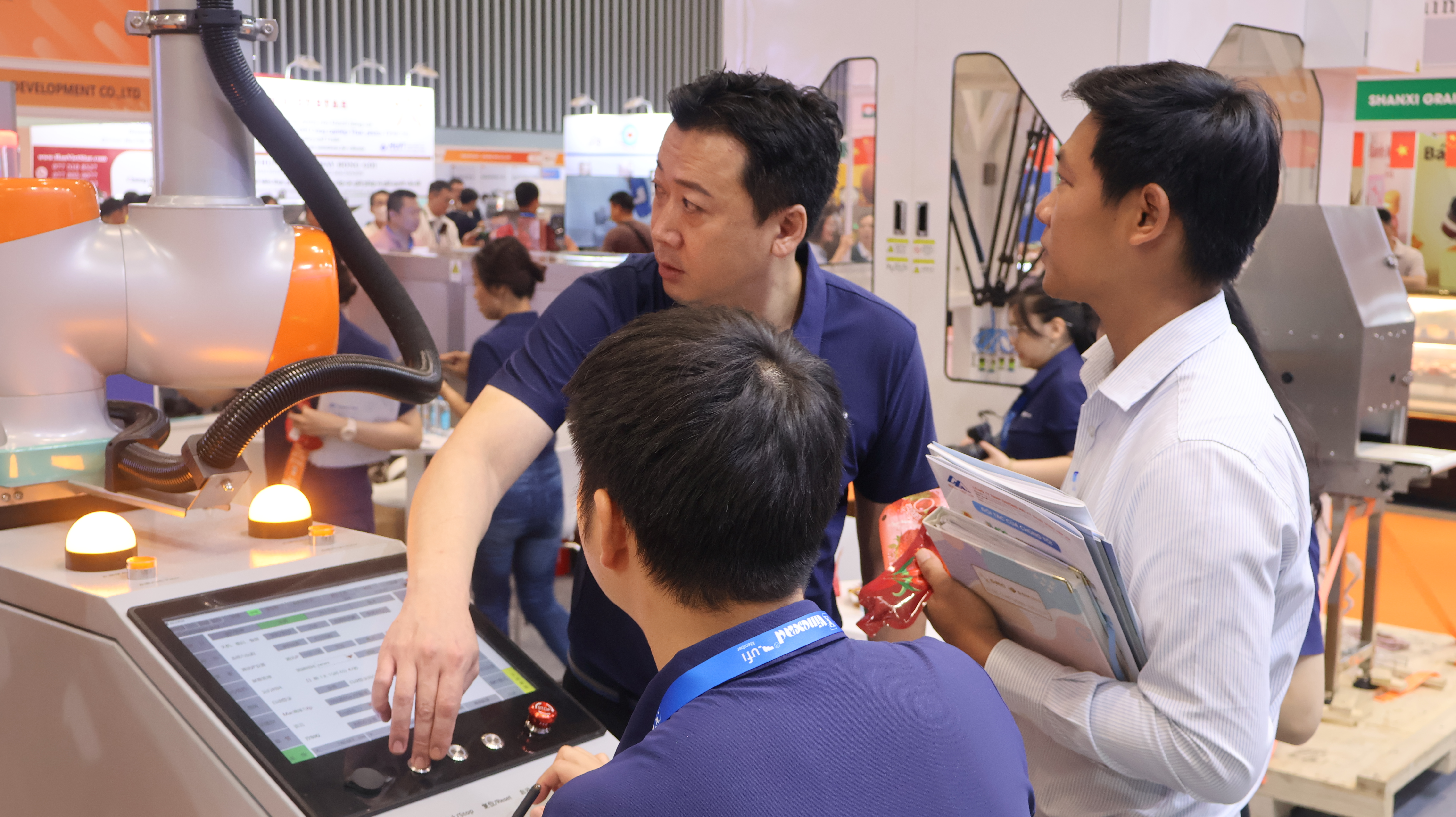 Jason Lai – Project Manager tại MUTTO, hướng dẫn khách tham quan điều khiển robot cộng tác xếp pallet tại triển lãm.